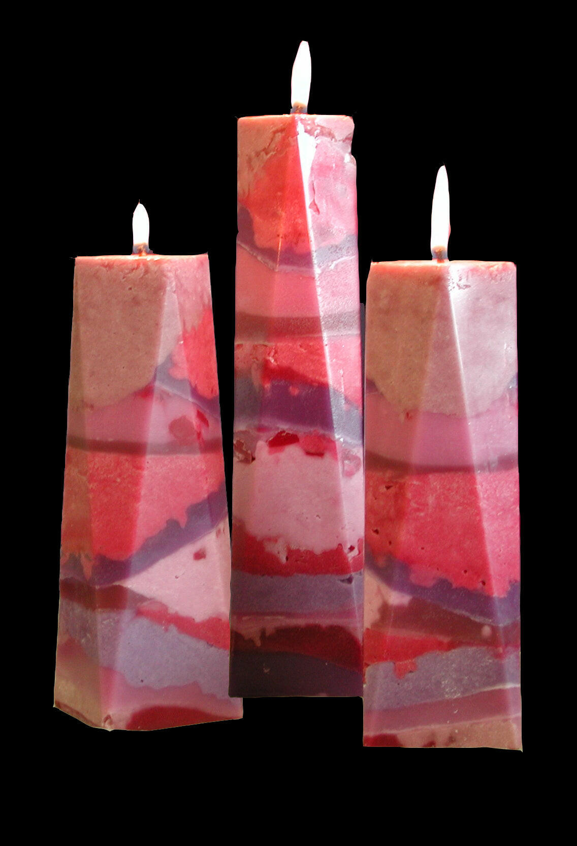 Wedding candles in marble pillars using pinks purple red
