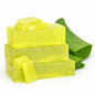 Stack of yellow melt and pour soap bars with aloe vera leaves on a white background
