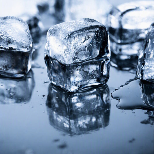 Black Ice Fragrance Oil depiction. A close-up of clear ice cubes on a glossy wet surface with reflections, tinted in a cool blue cast.