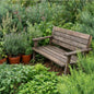 Botanical Garden Clean Fragrance Oil is depicted by A weathered brown wooden garden bench placed in a lush green garden among potted plants and foliage.