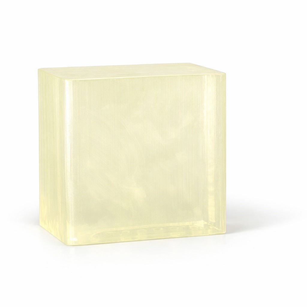 Rectangular block of light yellow clear melt and pour soap base on a white background