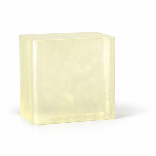 Rectangular block of light yellow clear melt and pour soap base on a white background