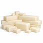 Stacked creamy white goat milk soap base pieces in assorted sizes arranged on a white surface.