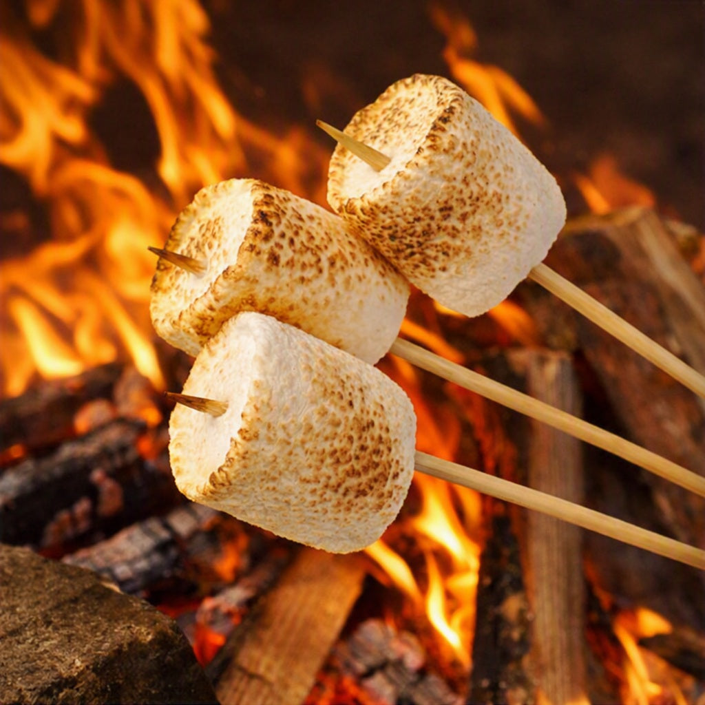 Gooey Marshmallow Fragrance Oil represented by 3 toasted marshmallows over a fire.