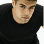 A close-up shot of a man wearing a black crew-neck t-shirt, looking directly at the camera against a plain white background. Used to represent the Issey Miyake Fragrance Oil.