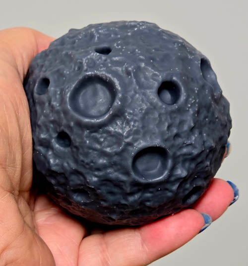 Dark gray moon candle held in hand