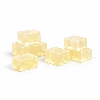 Five translucent light yellow cubes of soap base on a white background