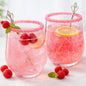 Two pink sparkling cocktails in clear stemless glasses, rimmed with pink sugar and garnished with raspberries, mint, and lemon slices, set on a light surface with additional raspberries around them. Gives the feel for the smell of Pink Fizz Clean Fragrance Oil.