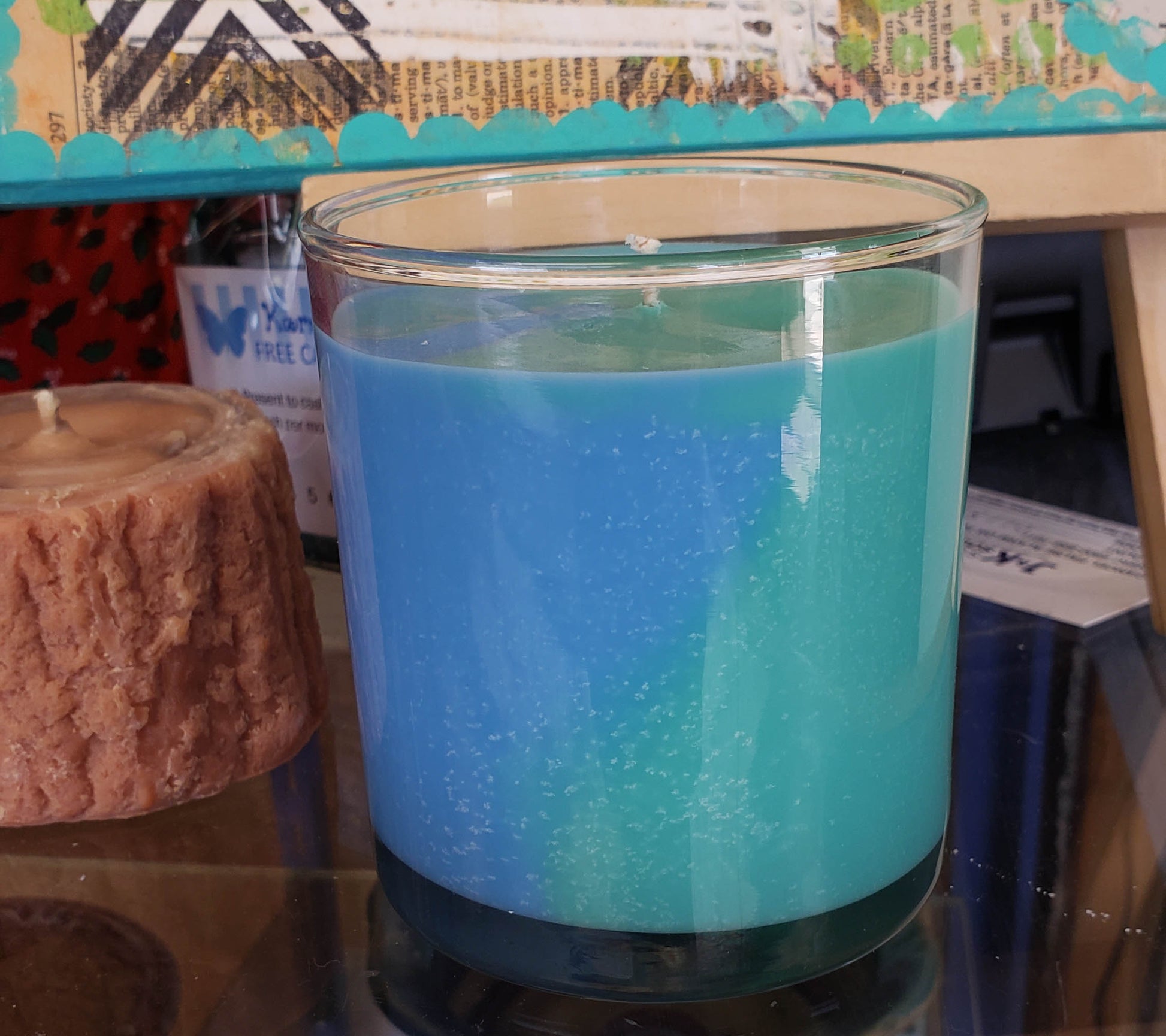 Two sided candle of blue and green made in a Madison candle jar