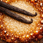 Two dark vanilla bean pods resting on coarse white sugar, surrounded by a ring of glistening amber honey on a rustic wooden surface. This is the smell of Warm Vanilla Sugar Fragrance Oil from Northstar.
